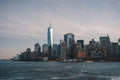 New York skyline with water view with sun low in sky. Photo by Willian Justen de Vasconcellos: https://www.pexels.com/photo/new-york-city-skyline-featuring-one-world-trade-center-32922191/